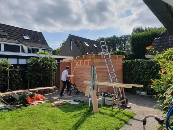 Timmerman van Klusbedrijf Wajer bouwt een houten tuinschuur in Wezep